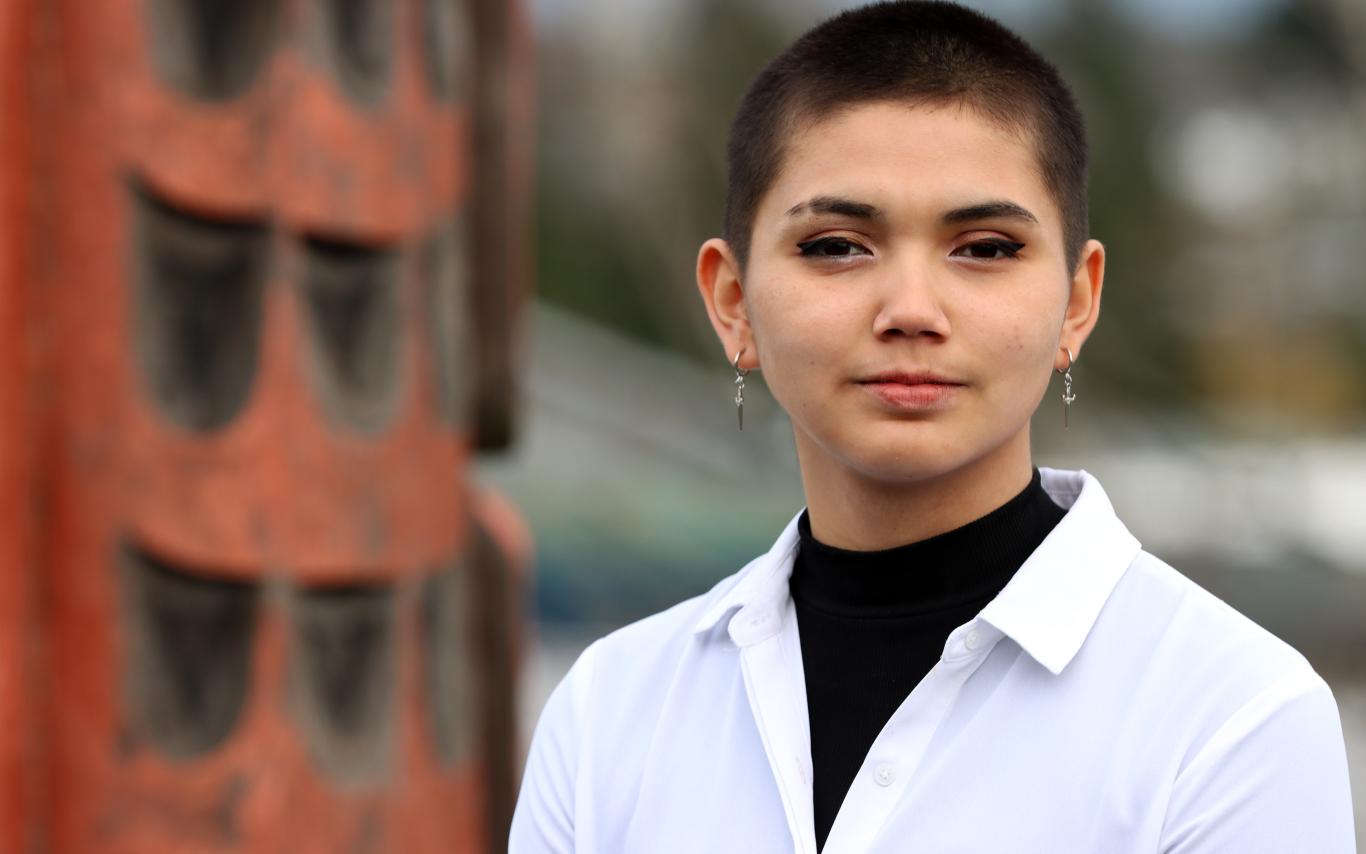 Portrait of Talela Manson with Coast Salish totem pole in background