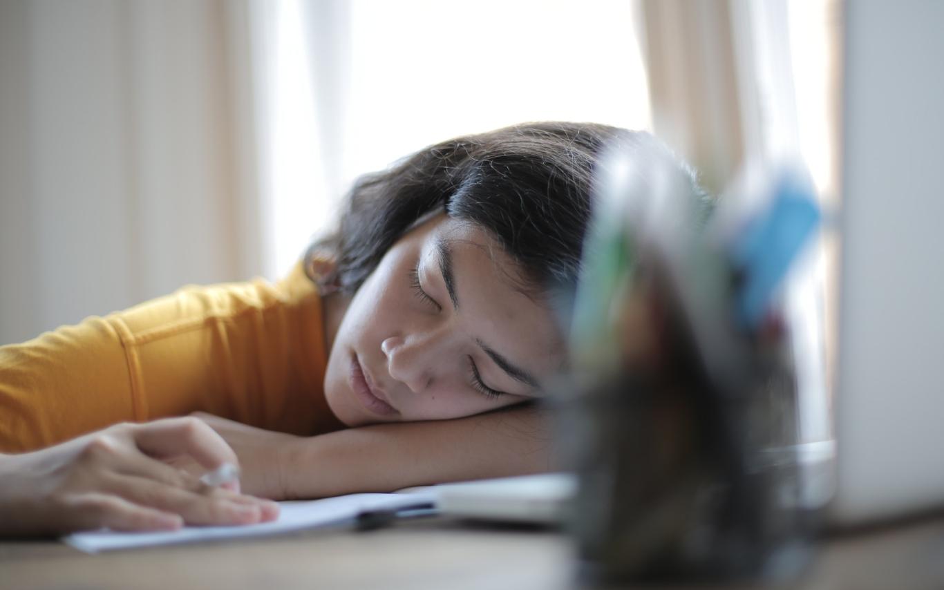 Student sleeping on her books