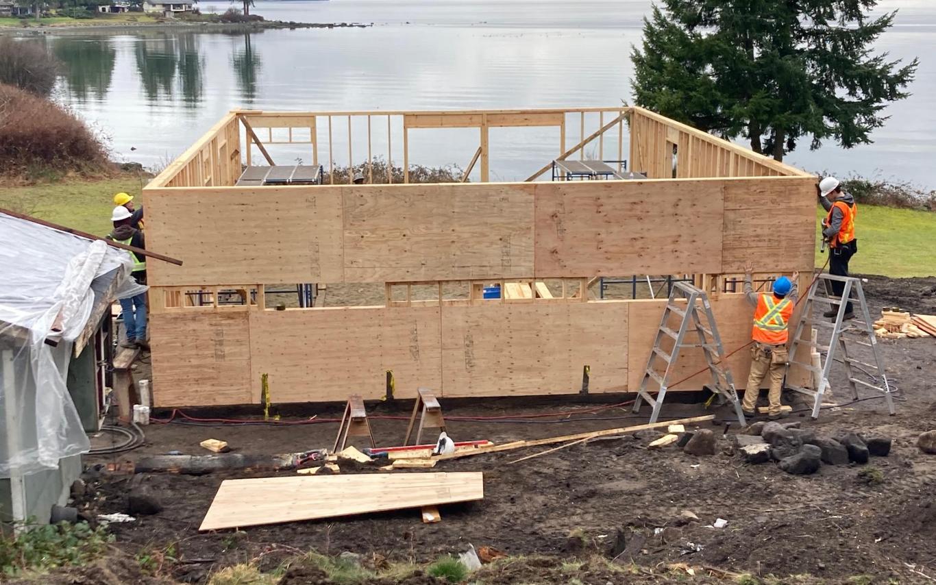 Students frame up a home with an ocean view in the background