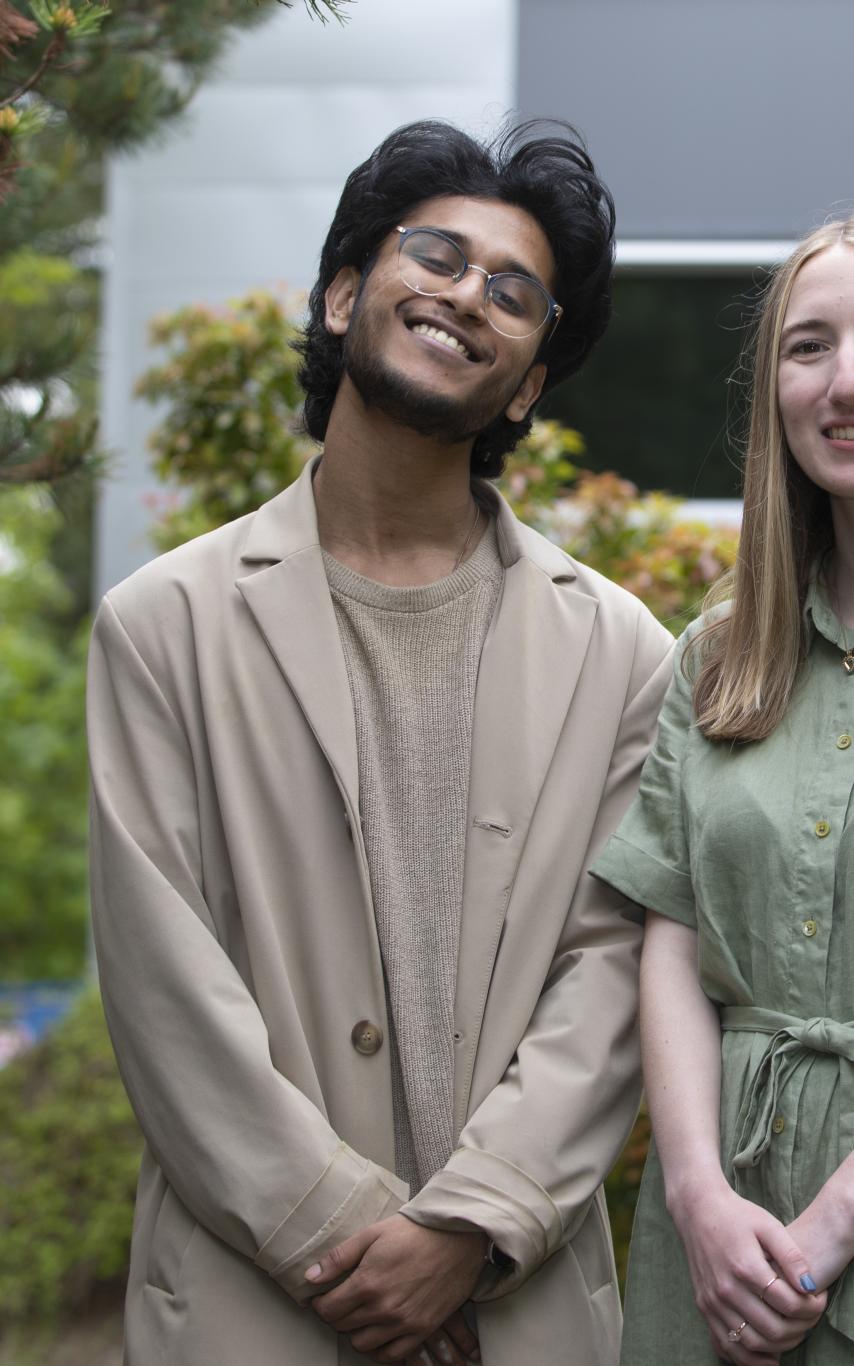 Siddhanth Arikari and Lauryn Mackenzie stand together in a garden area.