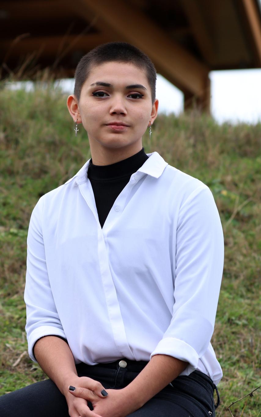 Talela sits on a rock outside the Gathering Place